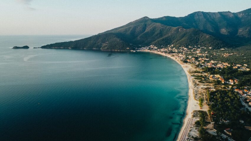 aerial view of green mountain beside body of water during daytime